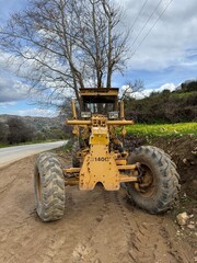 An old yellow construction tractor left abandoned and weathered by time, showing signs of rust and...