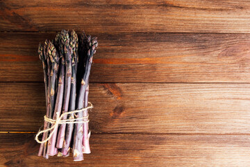 Freshly harvested asparagus bundles on wooden surface ready for cooking