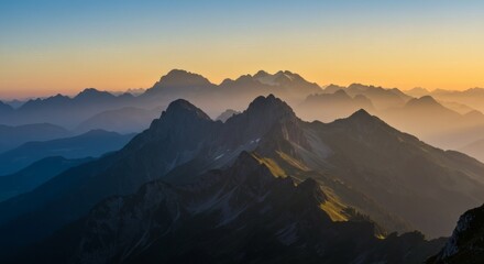 Majestic mountain peaks silhouetted by a golden sunset over layers of serene ranges.