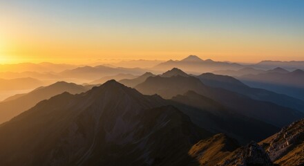 Naklejka premium Sunrise paints the mountain range with golden hues, creating a breathtaking panoramic view.