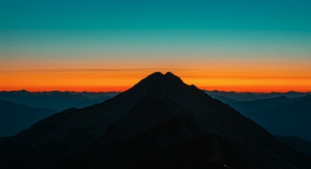 Stunning sunset paints the sky with vibrant colors over mountain silhouettes in the evening.