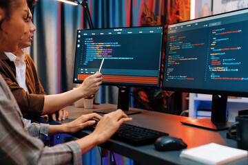 IT developers discussing with point to intelligent website development coder system running data...