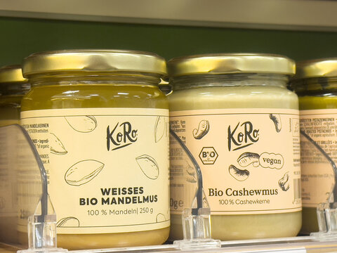 Organic almond and cashew butters in glass jars on store shelf