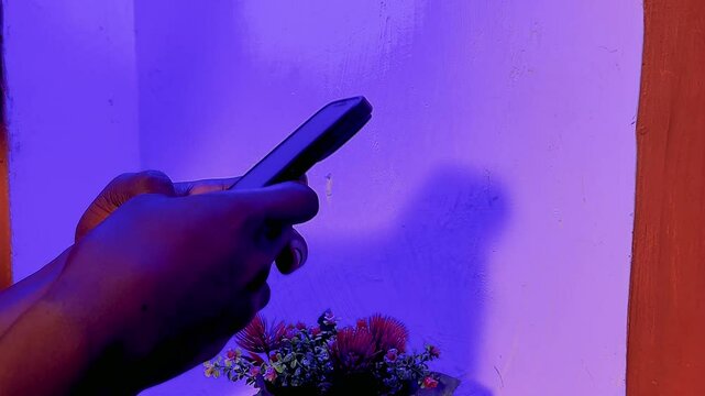 handing using phone while isolated over blue wall background.
