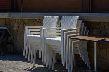 White plastic chairs arranged near a beach bar on the coast of Cyprus. Sunny day, relaxed summer vibe, Mediterranean setting, vacation mood.