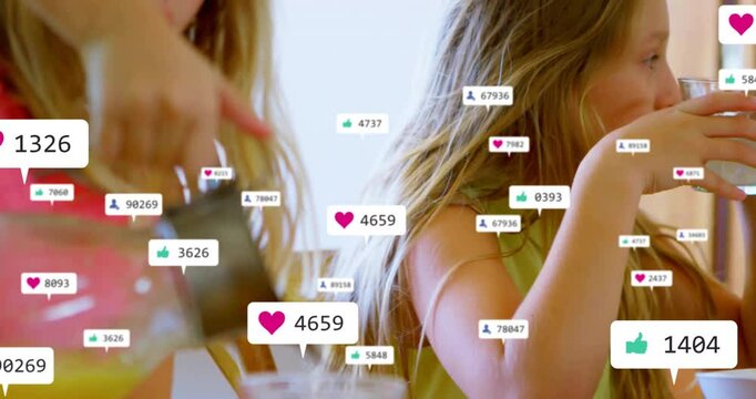 Two girls holding spoon and lifting glass at breakfast, showing floating digital marketing icons