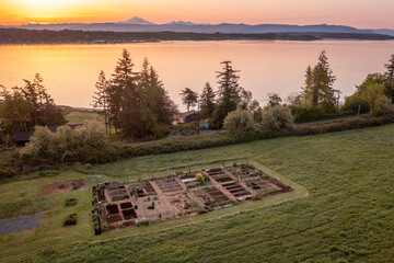 Aerial view of a Community garden located on an island in the Pacific Northwest. Beautiful morning light illuminates a garden area set aside on a land preserve in the Salish Sea area of Washington.