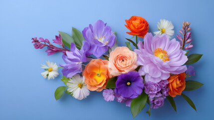 Obraz premium A vibrant arrangement of various blooming flowers, including roses, peonies, and freesias, are artfully displayed on a soft, blue-toned background, perfect for sp.