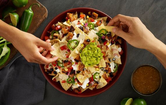 nachos with hands dipping