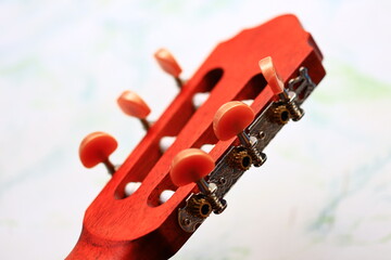 A detailed view of the frets and strings on a bright red guitar neck