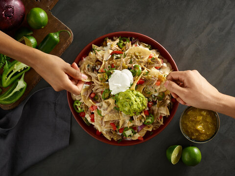 Friends enjoying pulled pork nachos