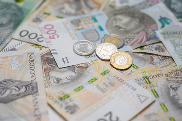 Assorted Polish zloty coins and banknotes photographed on a flat surface in Warsaw, Poland, in 2025. Image shows multiple denominations of national currency used in everyday transactions.