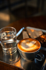 Hot coffee latte with latte art milk foam in cup mug and Homemade Brownie on wood desk on top view. As breakfast In a coffee shop at the cafe,during business work concept,vintage style