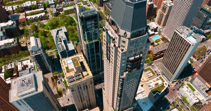 Flying to the top of a beautiful tower of Waldorf Astoria in Chicago, Illinois, USA. Low-rise architecture n lush greenery at backdrop. Top view.
