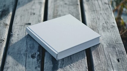 Fototapeta premium Blank white book on weathered wood surface simple mockup