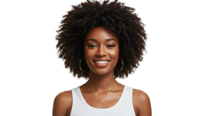 Portrait of a woman with afro hair, radiant smile and glowing skin wearing hoop earrings and a delicate necklace against black background.