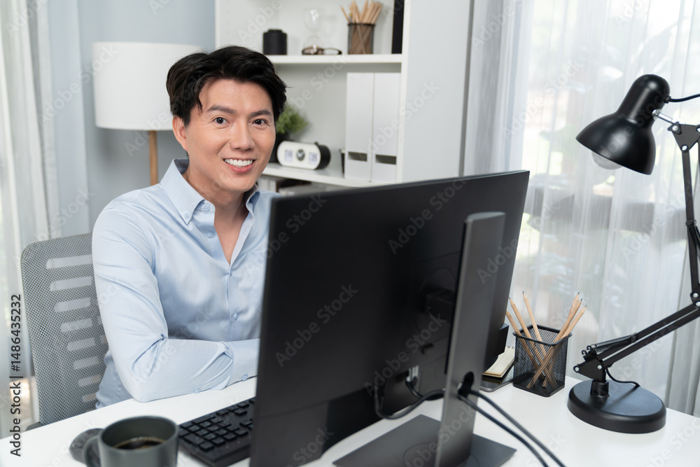 Poster portrait of smart businessman looking camera to pose while working on computer checking email wearin