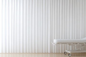 Minimalist interior featuring a pristine examination table against a backdrop of sheer white curtains, bathed in soft, natural light. Tranquil and sterile.
