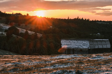 Stunning sunset over a rustic barn in a tranquil countryside landscape. Golden hour light...