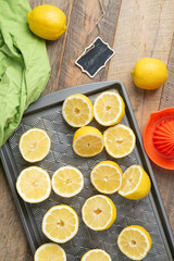 Lemons cut in halves on a baking sheet, preparing to make lemonade.