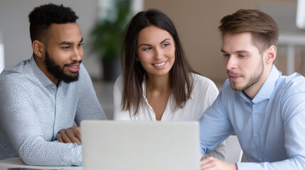 Diverse team collaborating around a laptop, engaged in a discussion