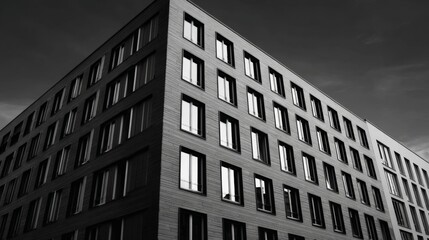 Obraz premium Modern Building Exterior Architecture - Black and white of a modern building's exterior, showcasing its architectural design and numerous windows