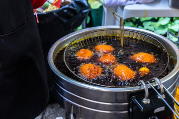woman fries the acaraje in palm oil on a tray in Brazil
