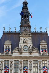 Fototapeta premium Paris City Hall decorated with national flags in sunny day.