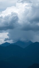 plane flying over a mountain range under a cloudy sky
