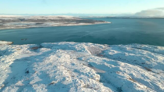 Drone footage of Scapa Bay and Scapa Flow, Orkney Islands, reveals the rugged, snow-dusted coastline of Scotland during winter in the North Sea.