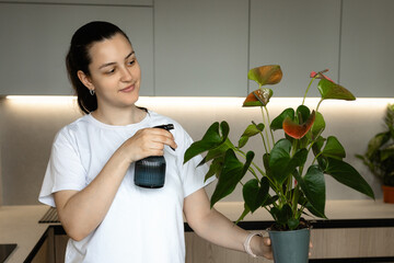 A girl holds a houseplant and sprays it, symbolizing care and growth. Perfect for plant care, home comfort, and natural aesthetics themes.