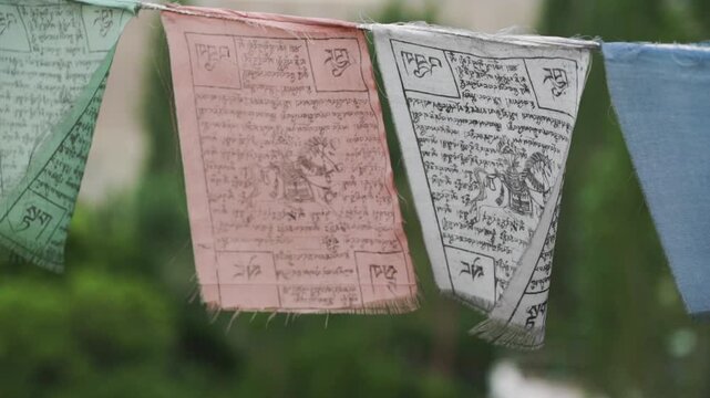Prayer flags with Tibetan script and symbols gently sway in the wind