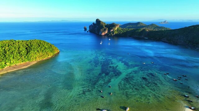 Aerial Beautiful Shot Of Nautical Vessels In Sea Amidst Island Mountains, Drone Descending Forward On Sunny Day - Phi Phi Islands, Thailand