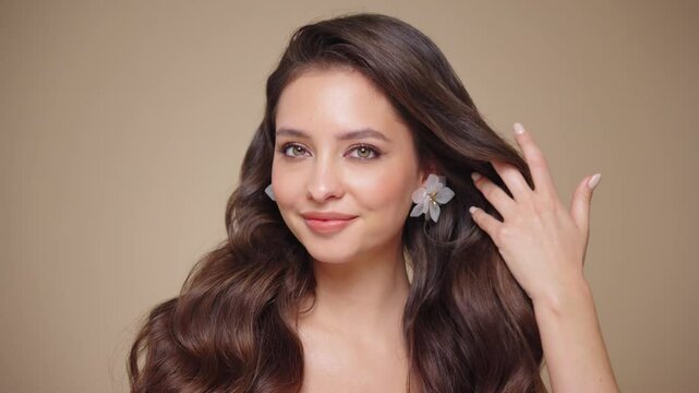 Beautiful model women have wave and shiny hair . Brunette girl with curly hairstyle, earrings and jewelry. Slow motion video