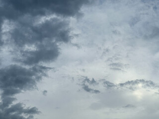 Stormy sky with dark, snowy clouds on a spring day. Clouds are floating across the sky. Dramatic clouds. Dark blue clouds swiftly floating across blue sky. Sky texture, abstract nature background.