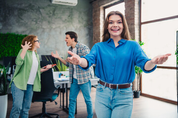 Happy young woman leading a diverse team in a modern office workspace with teamwork and...