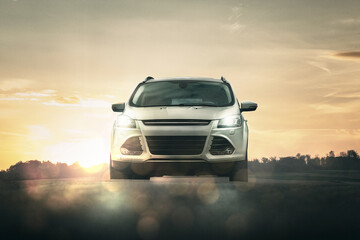 pkw von vorne auf straße mit schoner landschaft im hintergrund und strahlender sonne bei...