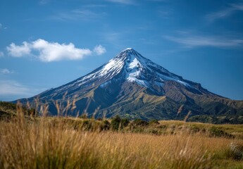 Fototapeta premium Majestic mountain with snowy peak under blue sky.