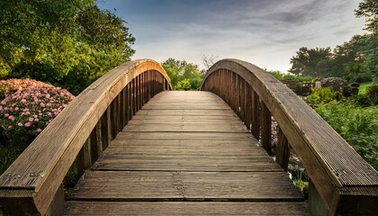 Obraz premium a rustic wooden bridge with a curved arch perfect for connecting pathways in gardens or natural landscapes