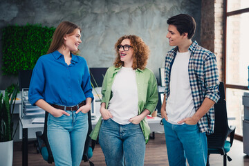 Young professionals engaged in friendly conversation in a modern coworking space showcasing...