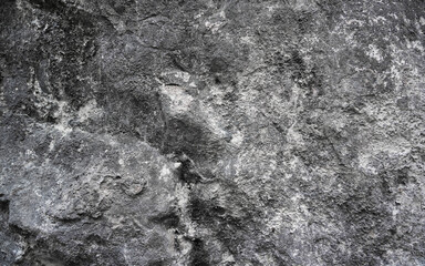 Close-up of rough concrete wall surface with natural cracks and texture. Aged cement background in gray tones, perfect for design or grunge effect overlays