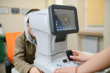 Ophthalmologist examining patient's vision with autorefractor in clinic