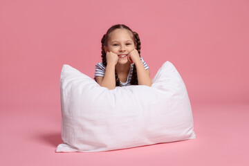 Cute girl with pillow on pink background