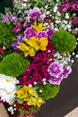 A vibrant bouquet featuring yellow lilies, pink carnations, white chrysanthemums, and lush green moss balls accented with delicate baby's breath, perfect for creative floral projects