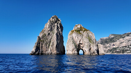 Fototapeta premium Faraglioni At Capri In Naples Italy. Island Landscape. Tourism Landmark. Faraglioni At Capri In Naples Italy. Bay Of Naples Skyline. Cultural Heritage Coastal. Paradise Capri Island.