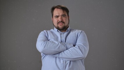 Man in Blue Shirt with Arms Crossed in Thought and Focus