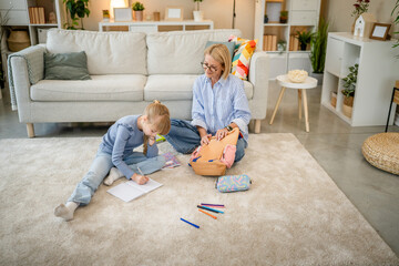 Grandmother help granddaughter do school homework together at home