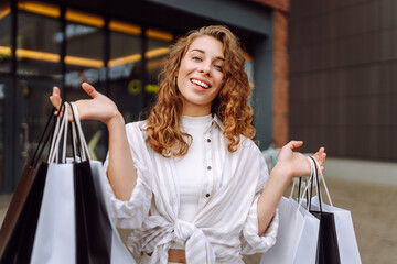 Cheerful woman after shopping enjoying the weather outside a mall. Young tourist after shopping...