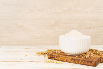 Bowl with spelt flour on wooden table