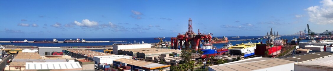 Obraz premium Panoramic view of the Astican shipyard in the port of Las Palmas with oil rigs, supply vessels and industrial port infrastructure on Gran Canaria